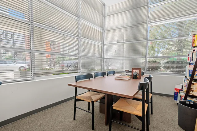 a view of a workspace with furniture and a window