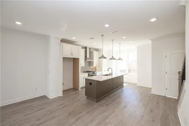 a view of kitchen with stainless steel appliances granite countertop cabinets and wooden floor