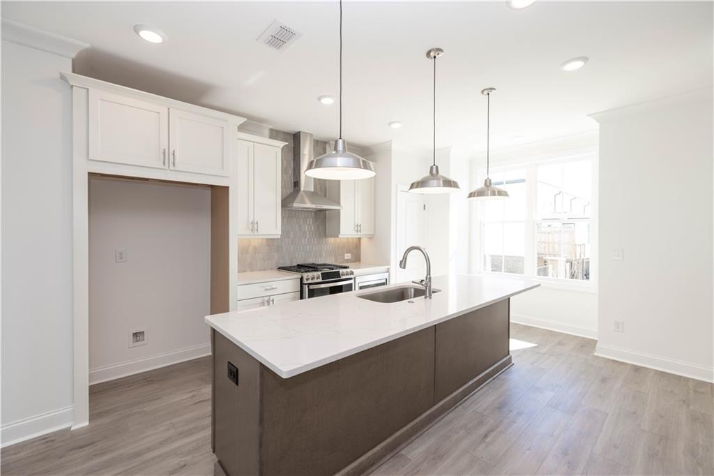4223 Millcroft Place, Unit 211 Buford, GA 30518 - Photo 12 of 47 a kitchen with stainless steel appliances and wooden floor
