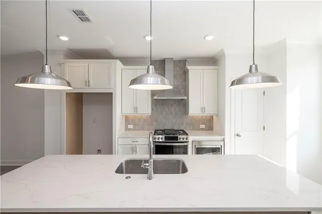 a kitchen with granite countertop a sink stainless steel appliances and cabinets