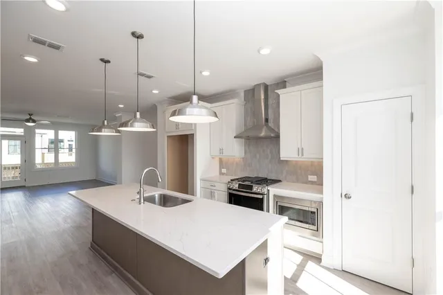 a kitchen with stainless steel appliances a stove a refrigerator and a window