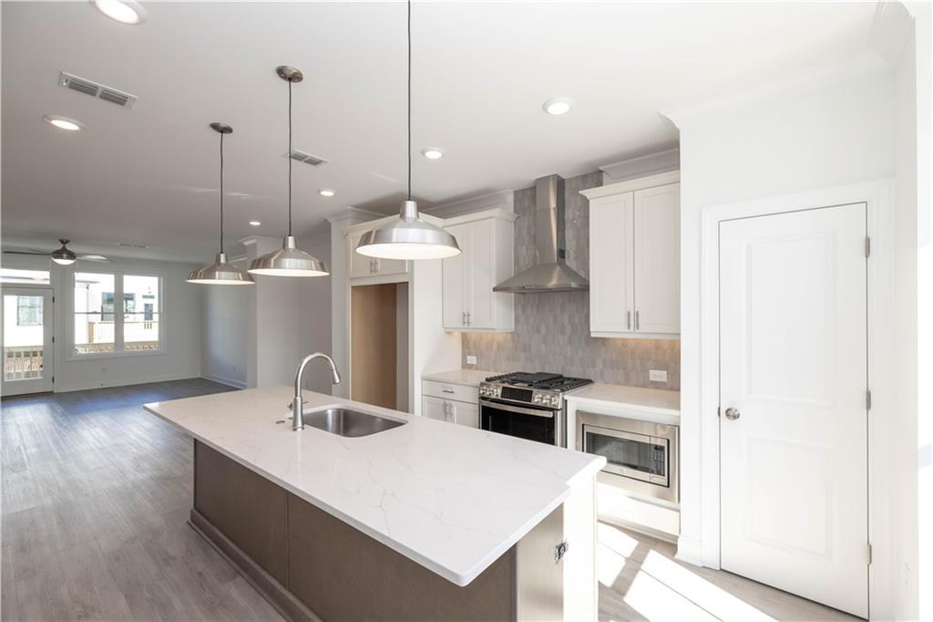 4223 Millcroft Place, Unit 211 Buford, GA 30518 - Photo 15 of 47 a kitchen with a refrigerator a sink and wooden floor