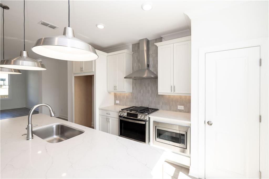 4223 Millcroft Place, Unit 211 Buford, GA 30518 - Photo 16 of 47 a kitchen with granite countertop a sink stainless steel appliances and cabinets