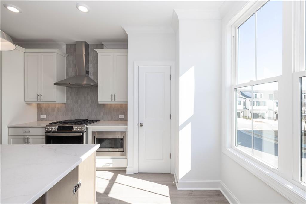 4223 Millcroft Place, Unit 211 Buford, GA 30518 - Photo 17 of 47 a kitchen with stainless steel appliances a stove a refrigerator and a window