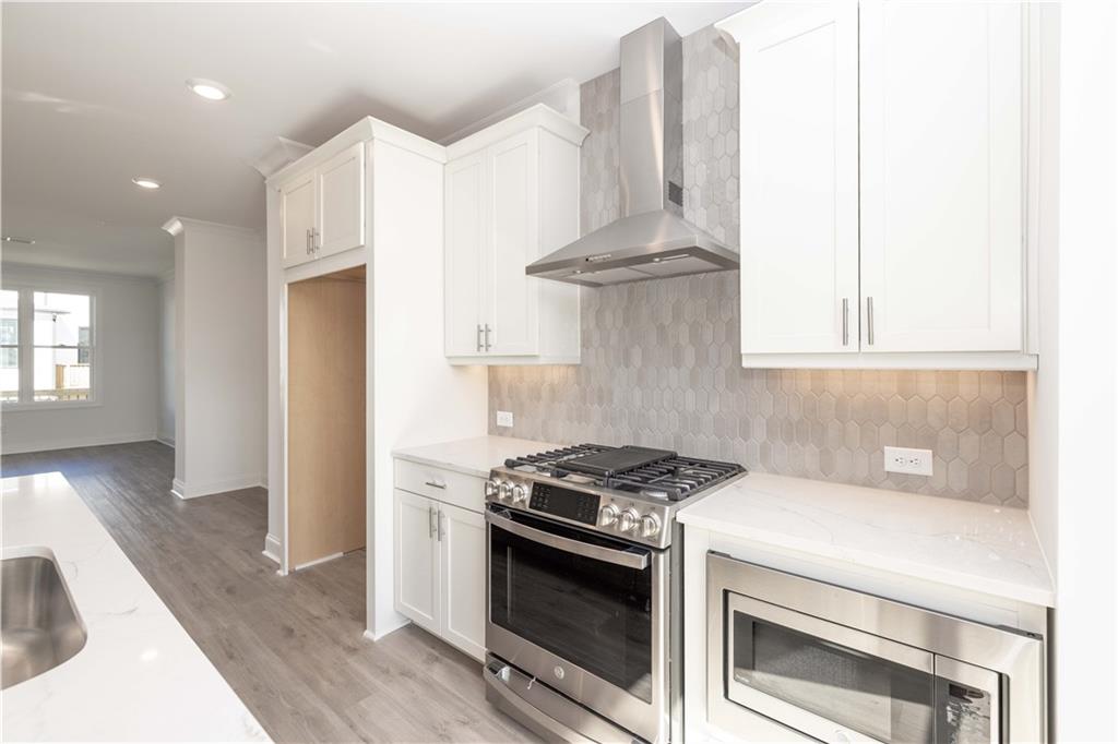 4223 Millcroft Place, Unit 211 Buford, GA 30518 - Photo 18 of 47 a kitchen with granite countertop a stove and a sink