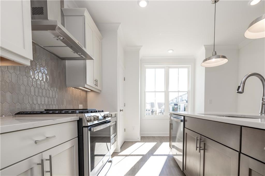 4223 Millcroft Place, Unit 211 Buford, GA 30518 - Photo 21 of 47 a kitchen with stainless steel appliances granite countertop a stove a sink and a refrigerator