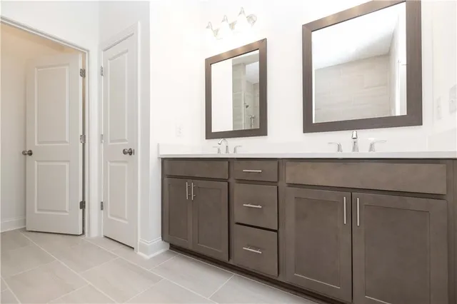 a bathroom with a double vanity sink mirror and shower