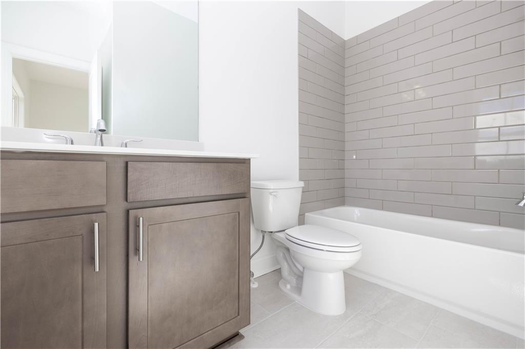 4223 Millcroft Place, Unit 211 Buford, GA 30518 - Photo 29 of 47 a bathroom with a toilet sink and mirror