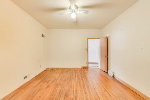 a view of a room with wooden floor and a ceiling fan