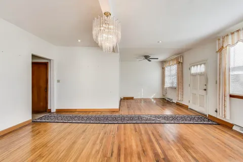 a view of a room with wooden floor and large windows