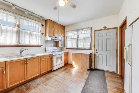 a large kitchen with cabinets and wooden floor
