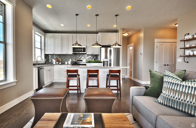 252 East Sandy Sage Way Sandy, UT 84070 - Photo 13 of 36 Open concept living area featuring wood-finish flooring, recessed lighting, and a kitchen island with pendant lighting