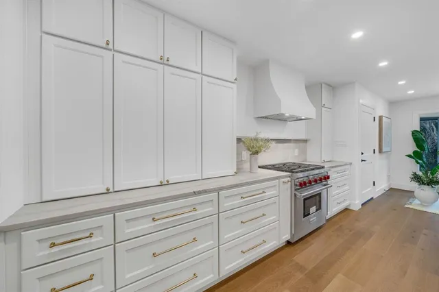 a kitchen with granite countertop white cabinets and stainless steel appliances