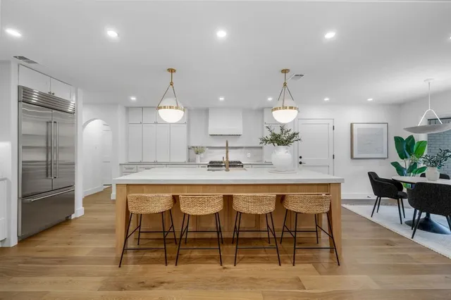 a kitchen with a dining table chairs and wooden floor