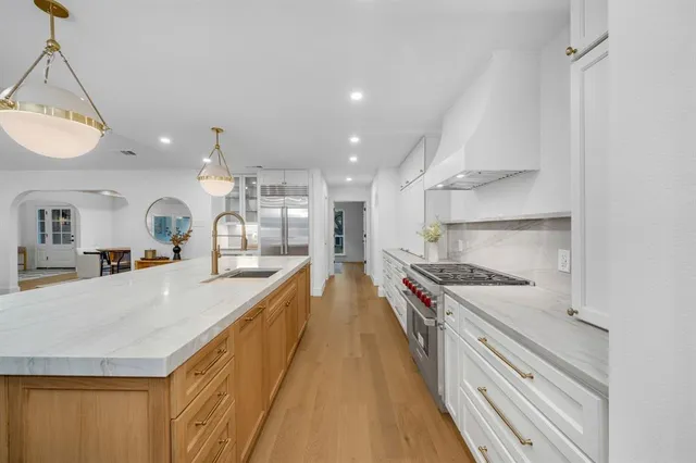 a large kitchen with stainless steel appliances granite countertop a lot of counter space