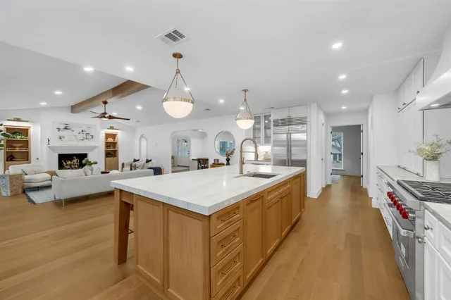 a large kitchen with stainless steel appliances kitchen island a stove and a view of living room