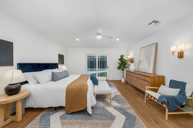 a large bedroom with a bed and wooden floor