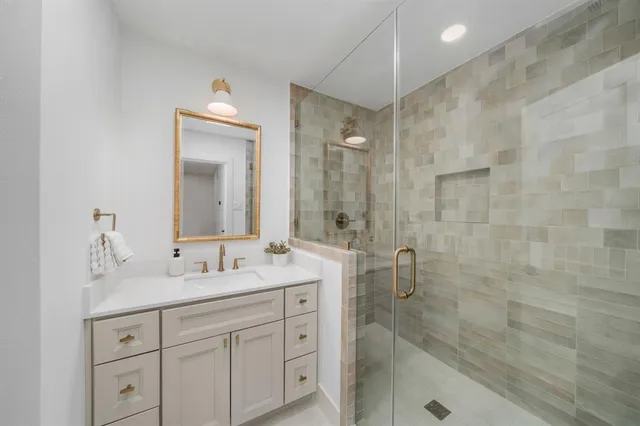 a bathroom with a double vanity sink toilet a shower and a mirror