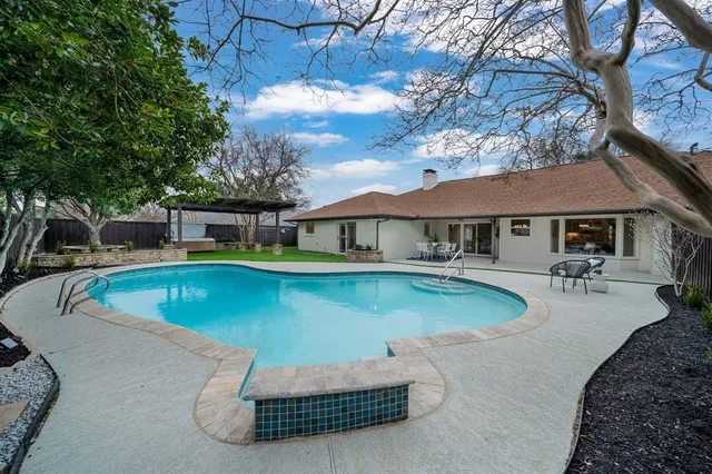 a view of a house with swimming pool and sitting area