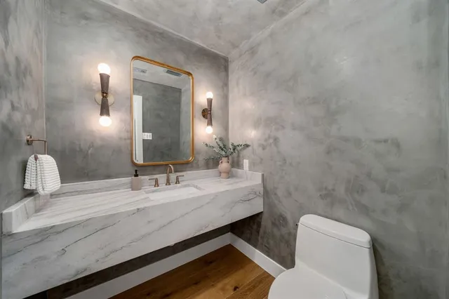a bathroom with a toilet a sink and mirror