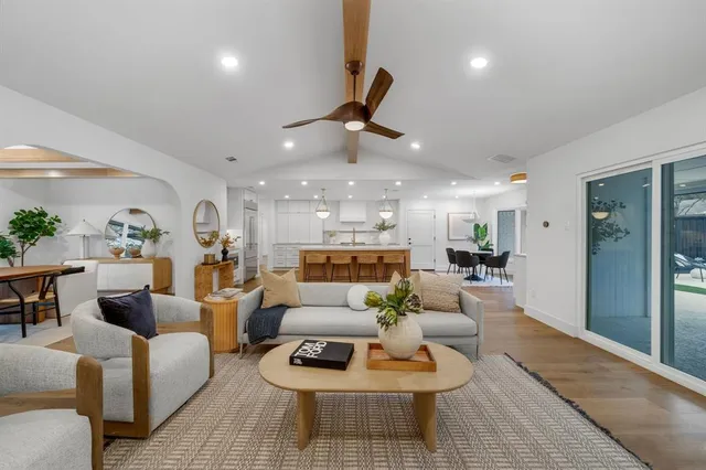 a living room with furniture kitchen view and a chandelier