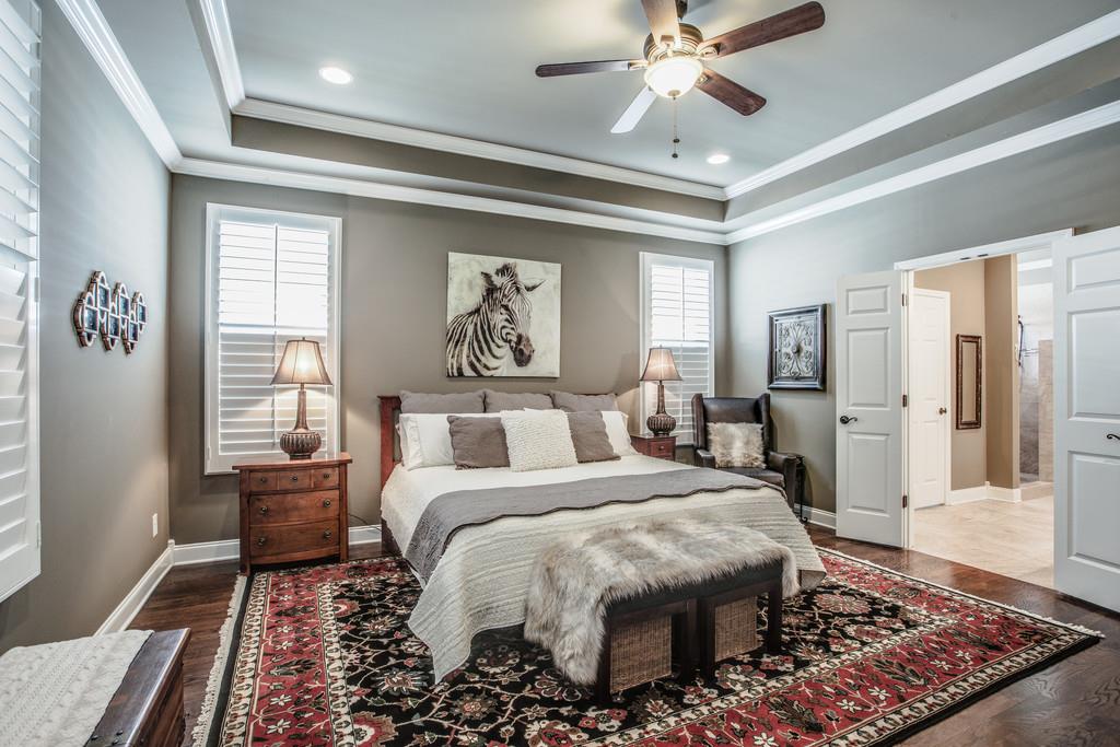 4128 Turnberry Road Spring Hill, TN 37174 - Photo 18 of 30 a bedroom with a large bed and a chandelier