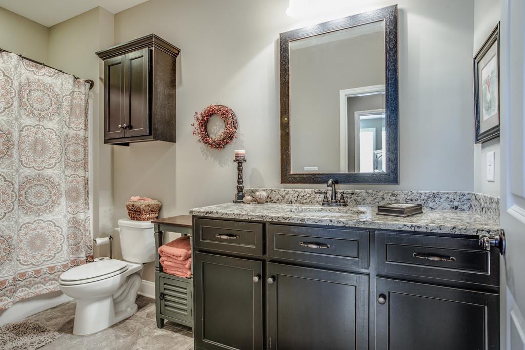 4128 Turnberry Road Spring Hill, TN 37174 - Photo 26 of 30 a bathroom with a granite countertop toilet sink and mirror