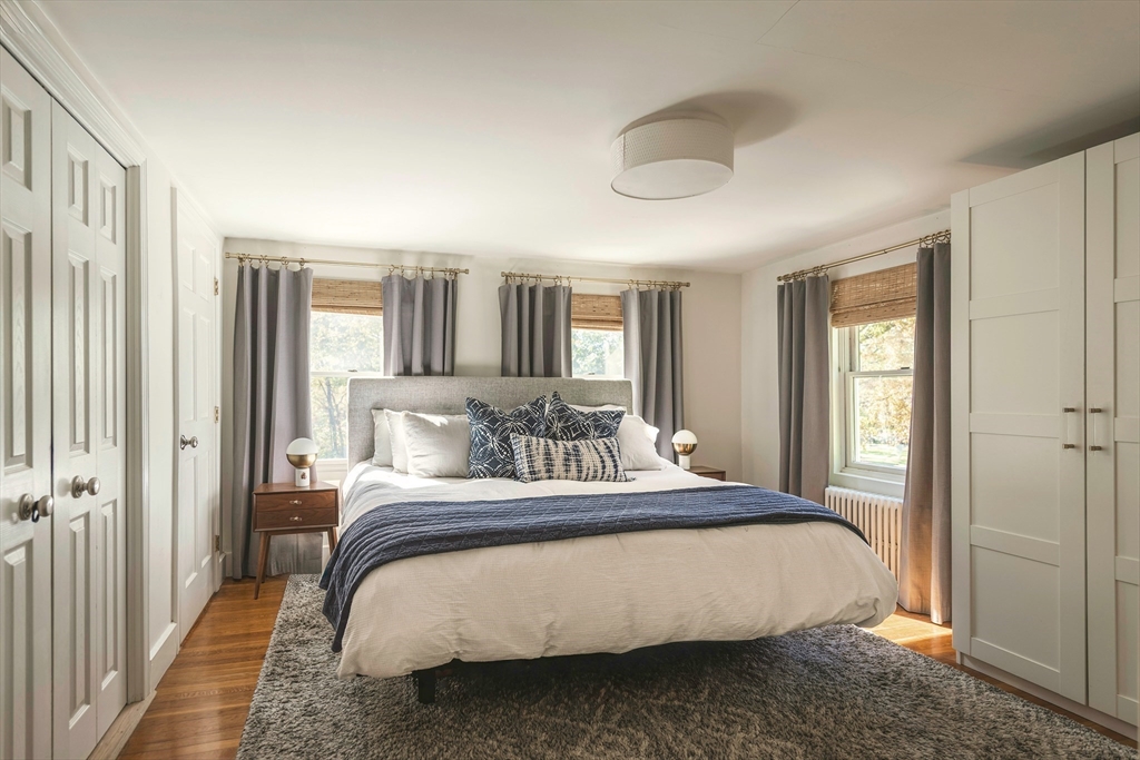 8 Old Essex Road Ipswich, MA 01938 - Photo 10 of 42 a bedroom with a large bed and a chandelier