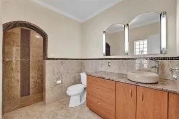 a bathroom with a granite countertop sink a toilet and a mirror