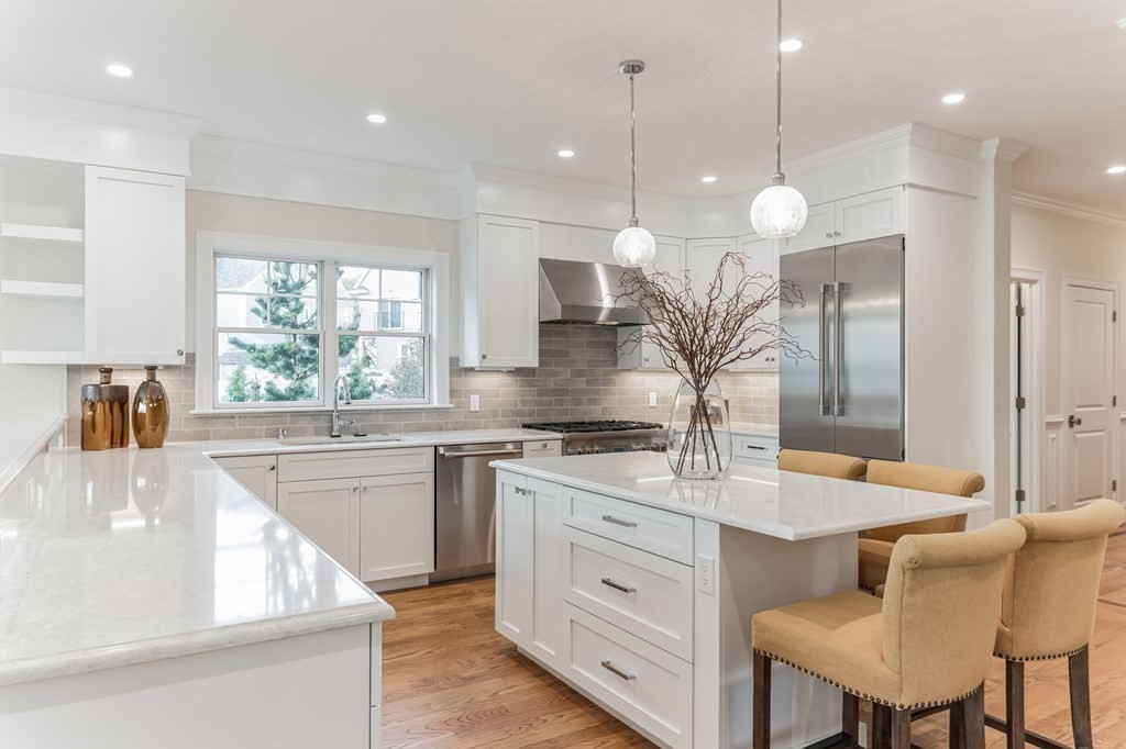 a kitchen with kitchen island granite countertop a stove a sink a center island and furniture