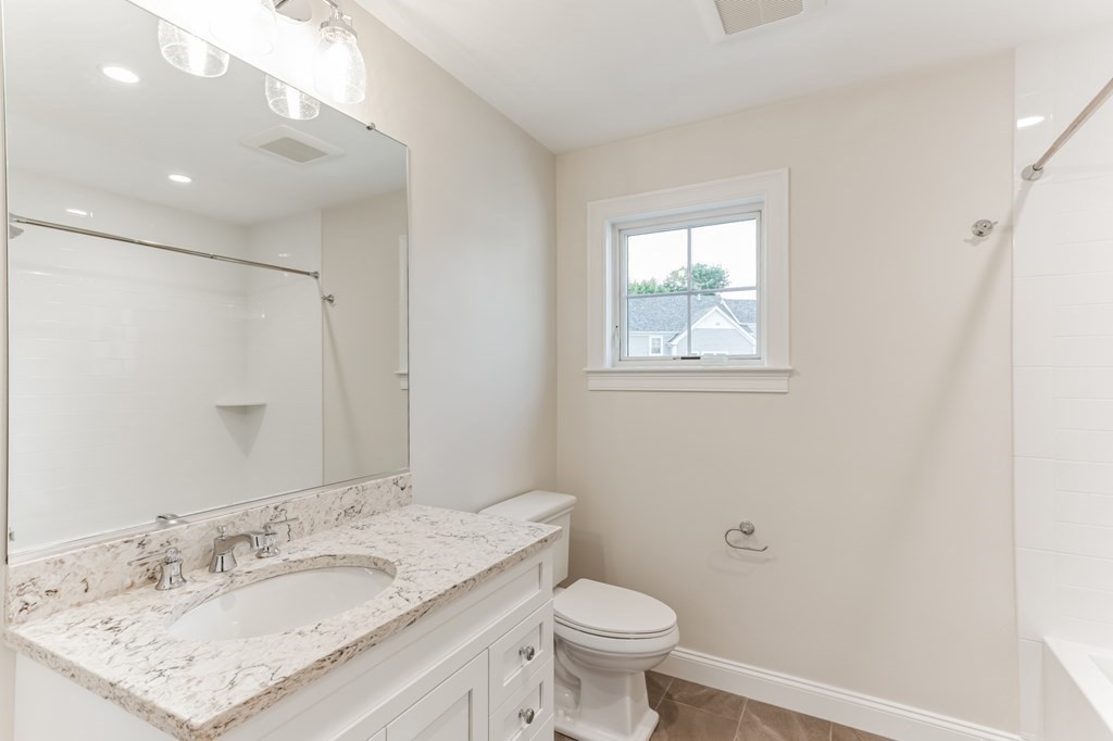 185 Hillside Avenue, Unit 185 Needham, MA 02494 - Photo 19 of 32 a bathroom with a granite countertop sink a toilet and a mirror