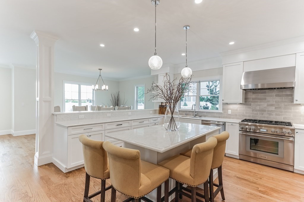 185 Hillside Avenue, Unit 185 Needham, MA 02494 - Photo 4 of 32 a kitchen with a dining table chairs sink and stove