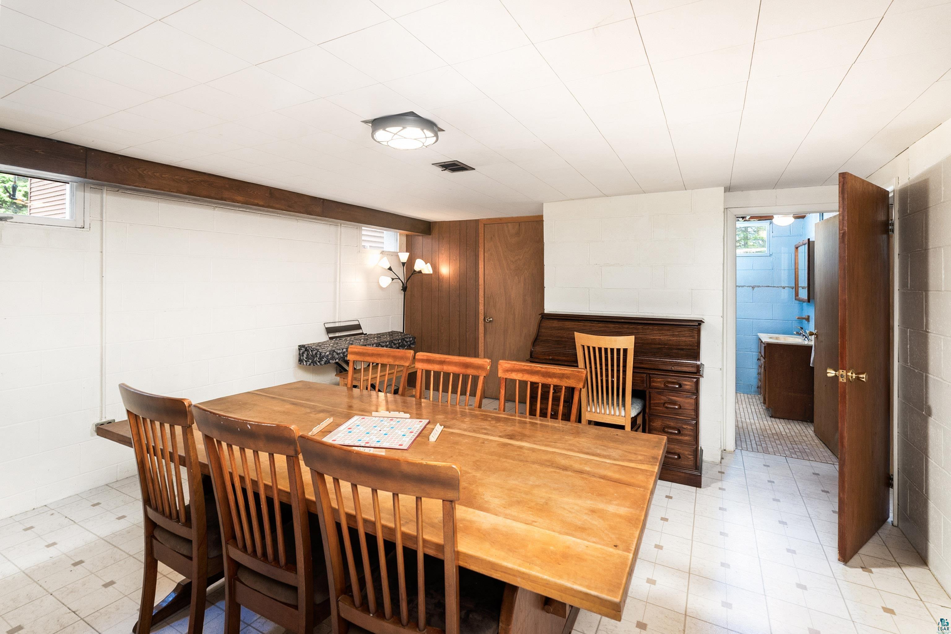 4808 Midway Road Duluth, MN 55811 - Photo 36 of 57 Versatile finished basement space featuring white block walls, a drop ceiling, and wood-finish flooring