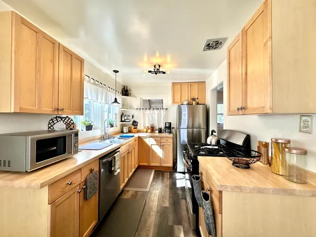 a kitchen with a sink a counter top space stainless steel appliances and a window