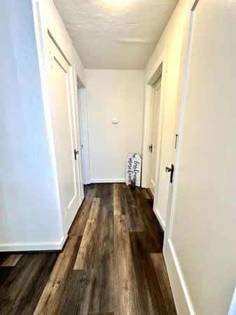 a view of a hallway with wooden floor and staircase