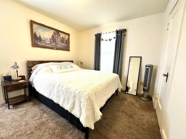 a bed sitting in a bedroom next to a window