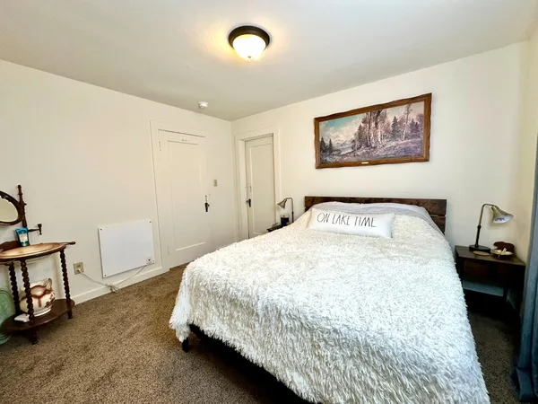 a bedroom with a bed and painting on the wall