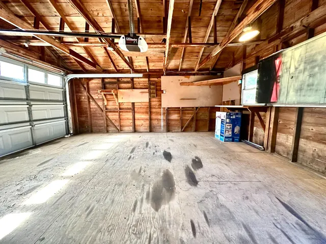 a storage room with water heater and a wooden floor
