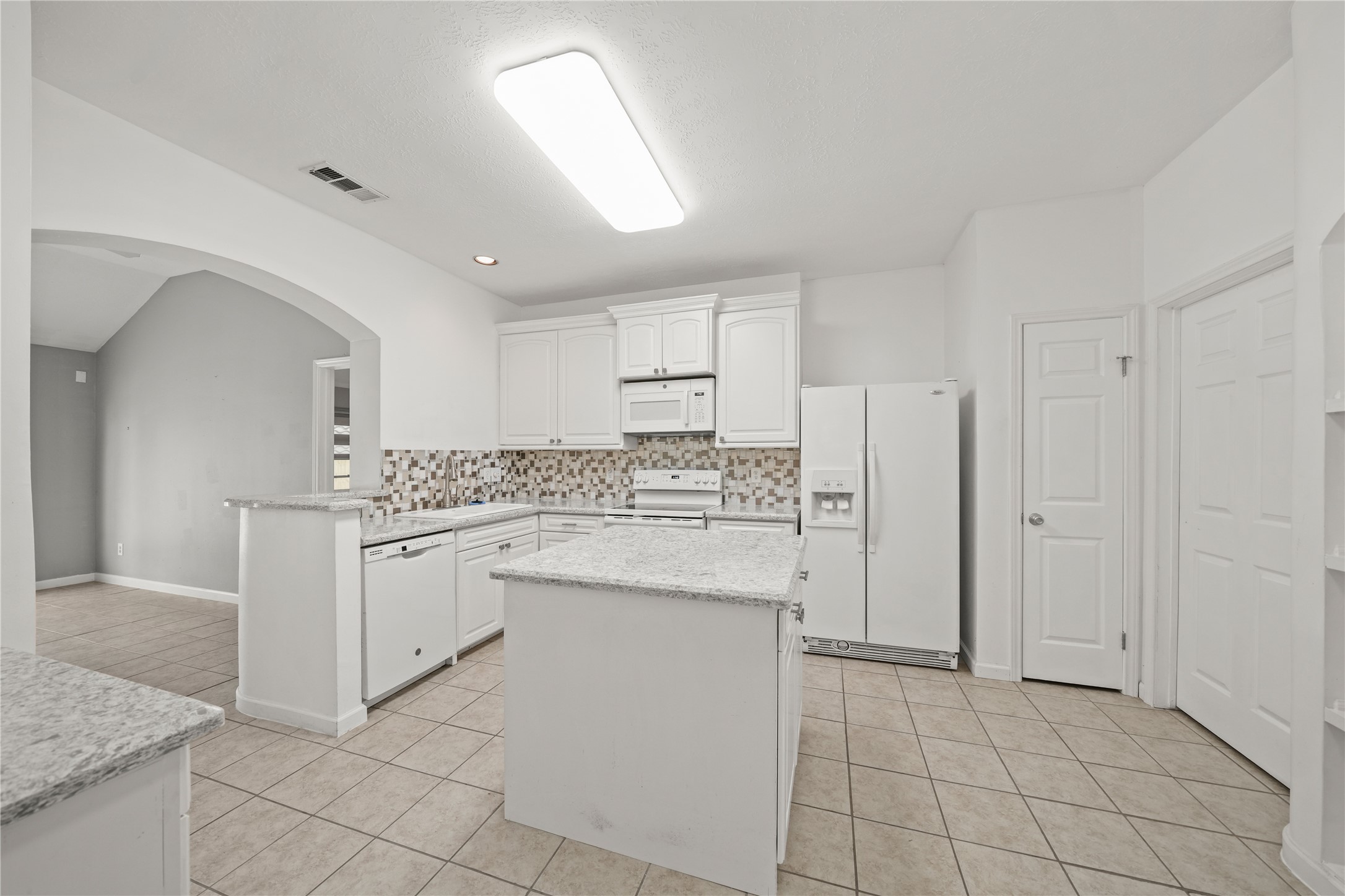8134 Blue Jay Street Baytown, TX 77523 - Photo 16 of 31 a kitchen with granite countertop cabinets and white appliances