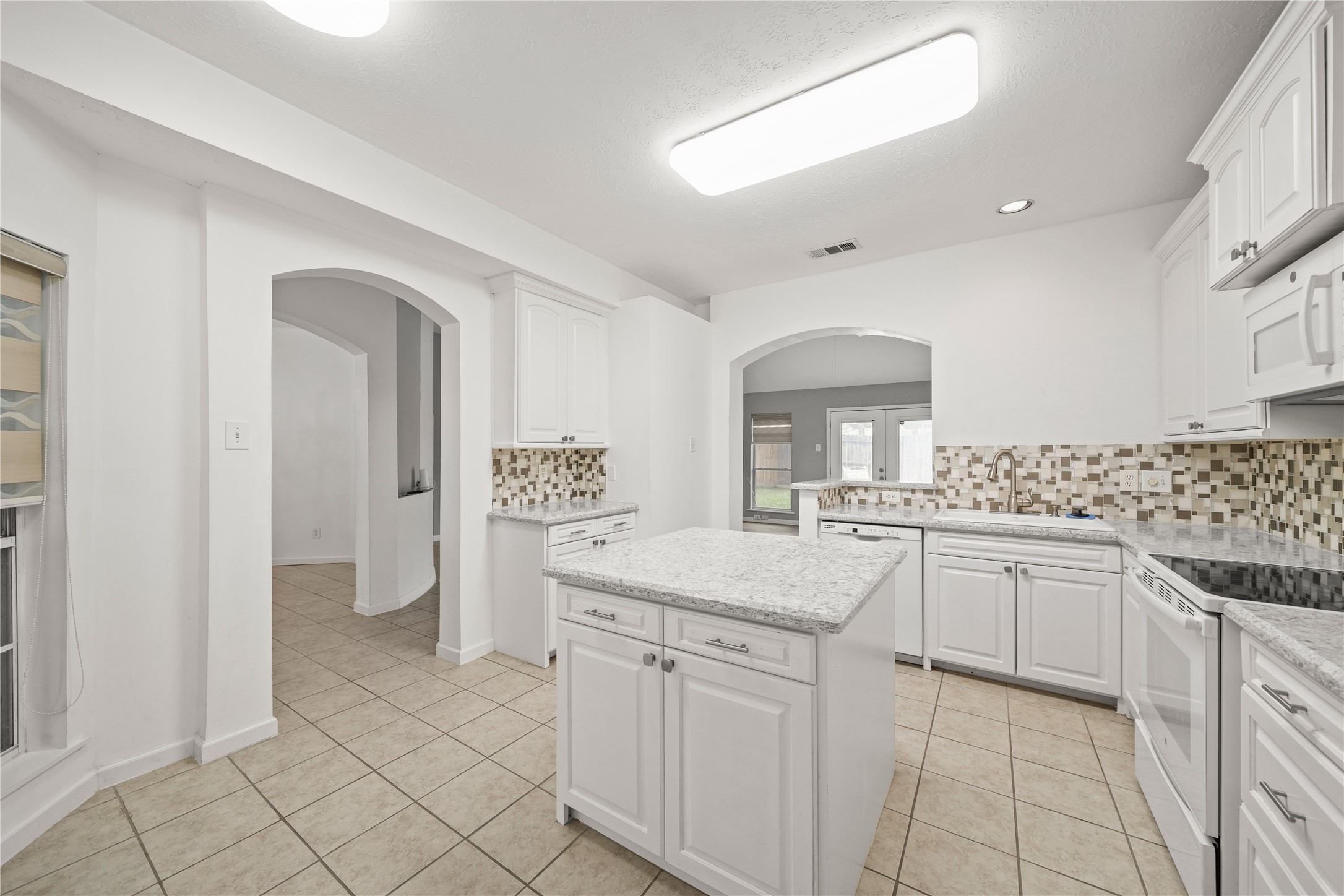 8134 Blue Jay Street Baytown, TX 77523 - Photo 17 of 31 a kitchen with granite countertop white cabinets and white appliances