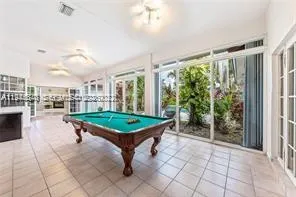 a room with pool table and windows