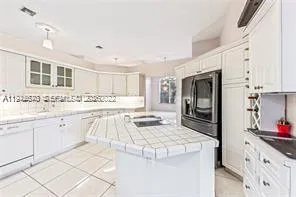 a kitchen with granite countertop white cabinets and stainless steel appliances