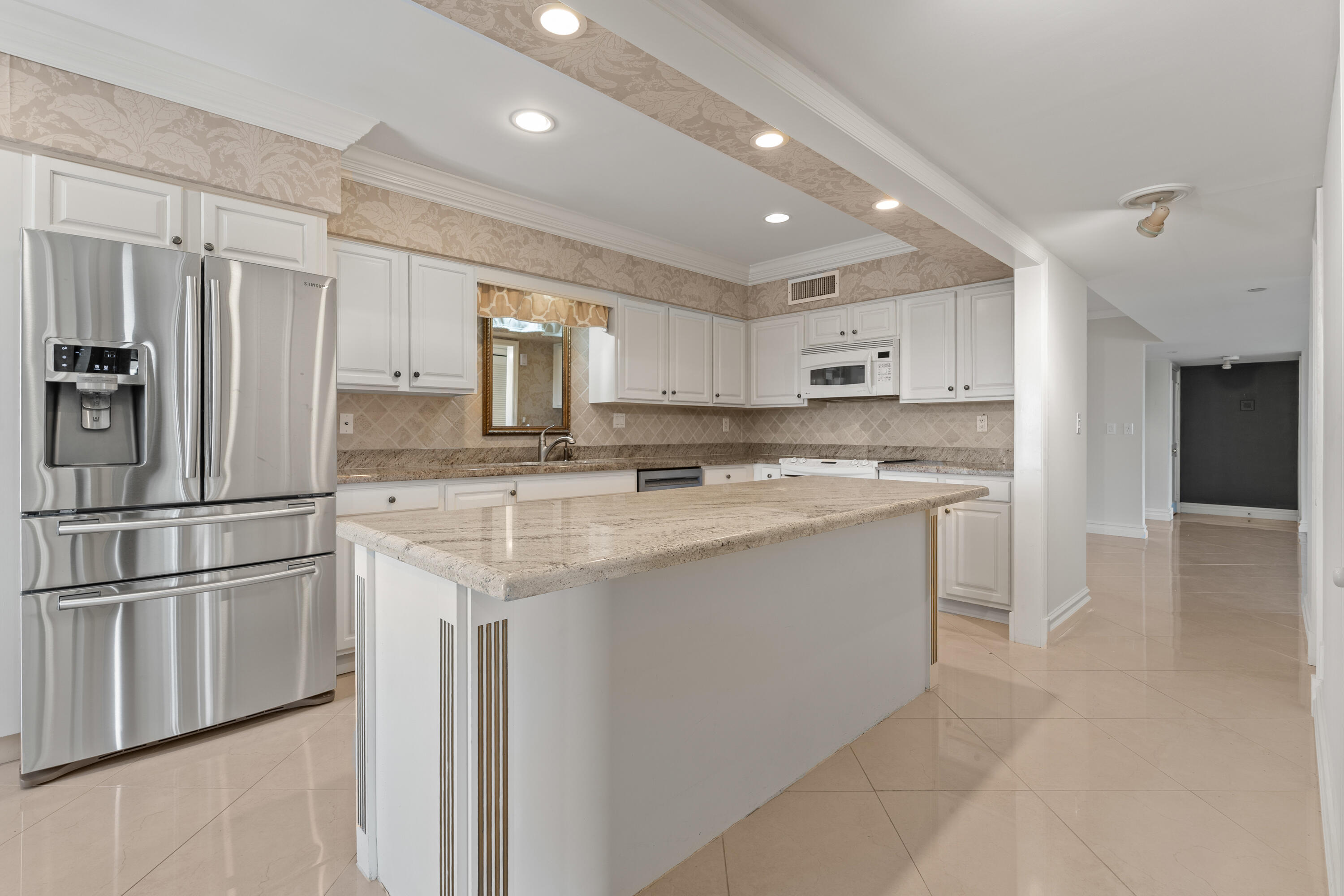 16940 Bay Street, Unit N504 Jupiter, FL 33477 - Photo 20 of 33 a kitchen with stainless steel appliances granite countertop a refrigerator and a stove top oven