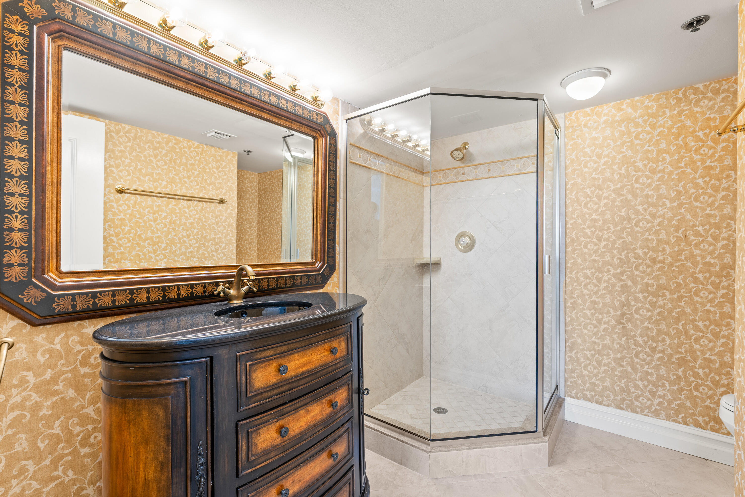 16940 Bay Street, Unit N504 Jupiter, FL 33477 - Photo 27 of 33 a bathroom with a sink a mirror and a shower