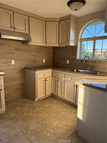 a kitchen with granite countertop a sink a stove and cabinets