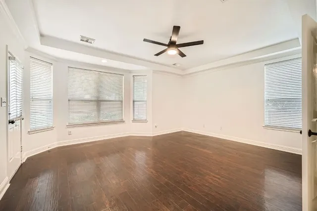 a view of an empty room with a window and wooden floor