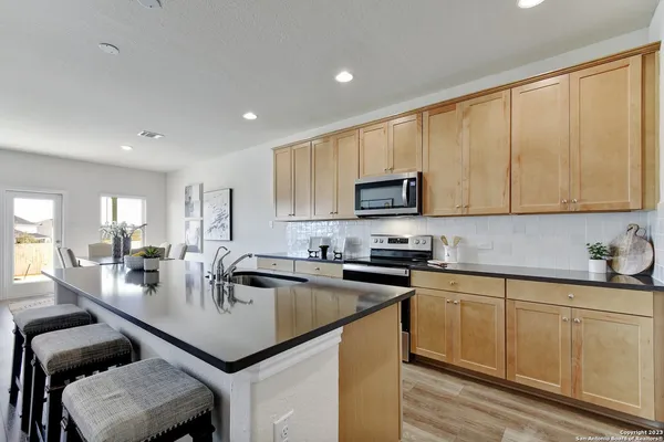 a kitchen with a sink a counter top space cabinets and stainless steel appliances