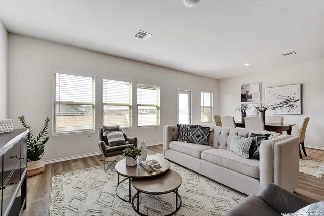 a living room with furniture and floor to ceiling windows