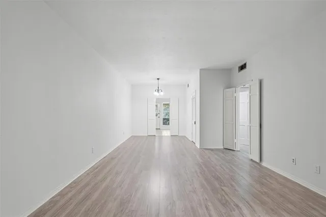 a view of a big room with wooden floor and windows
