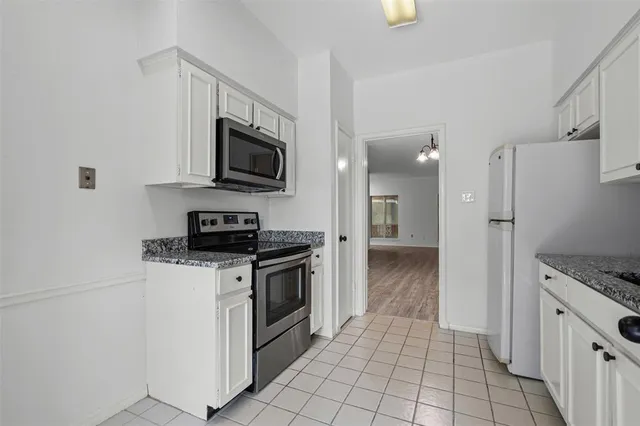 a kitchen with stainless steel appliances granite countertop a stove a refrigerator and a microwave